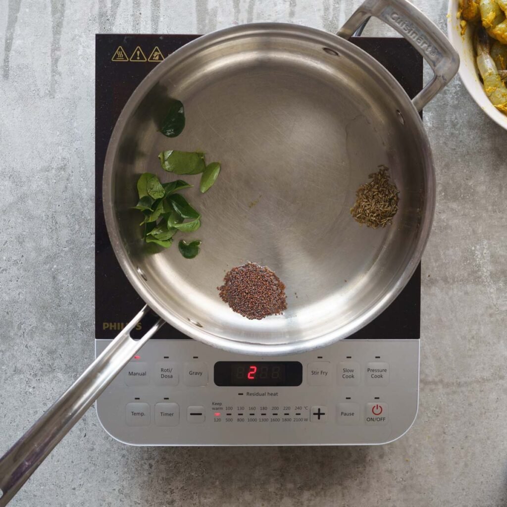 Pan with oil, curry leaves, mustard and cumin