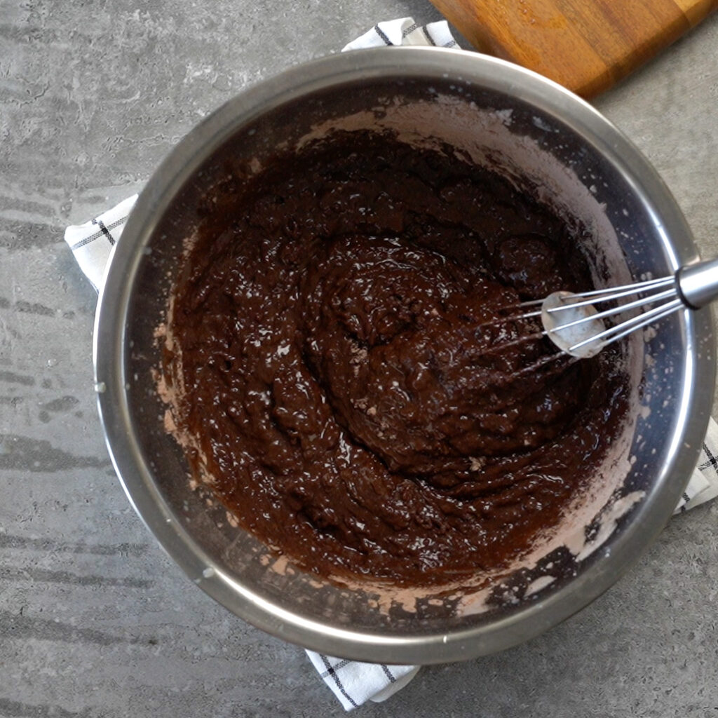 Making the eggless chocolate cake batter- Step 3 - Adding hot water