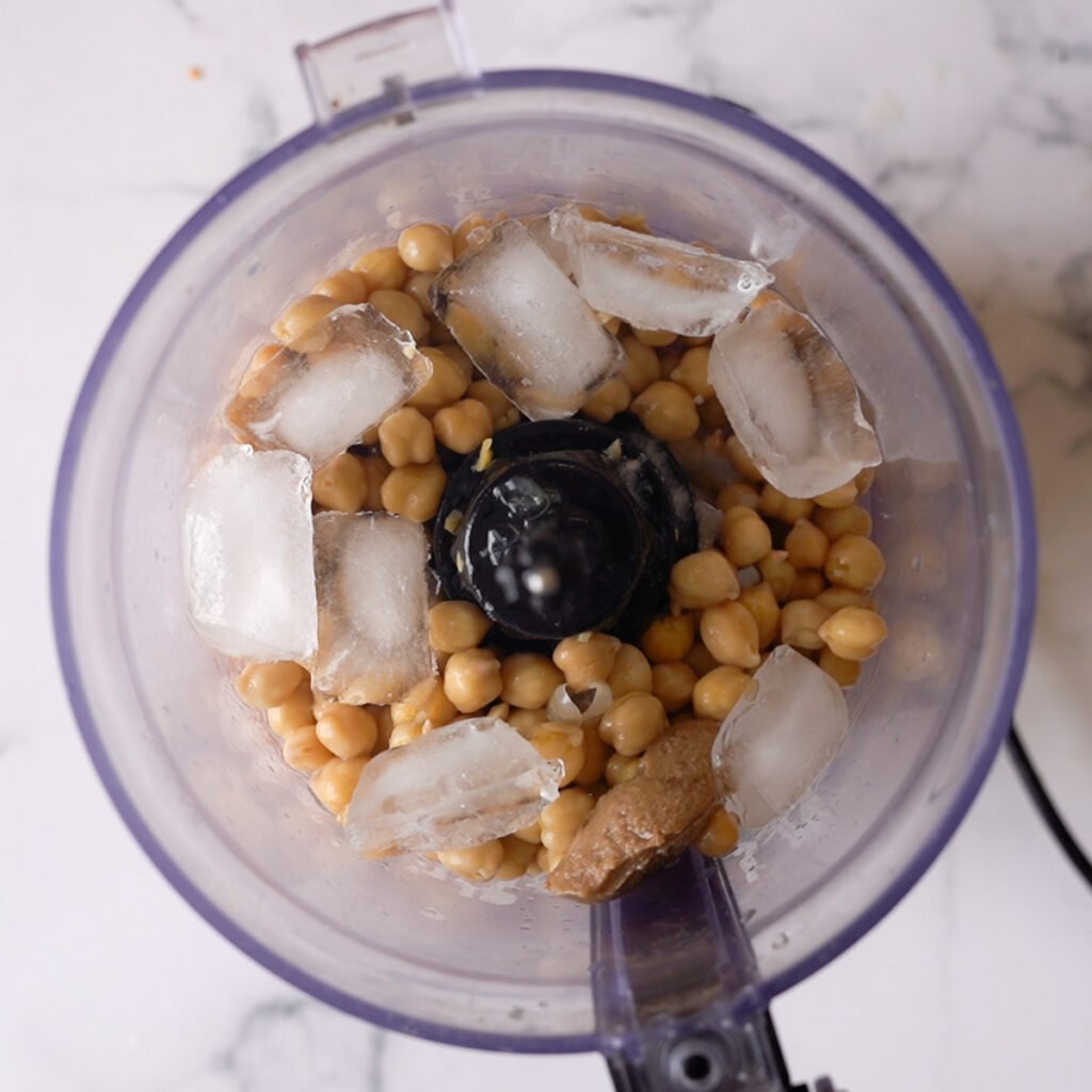 chickpeas in a blender with ice and tahini