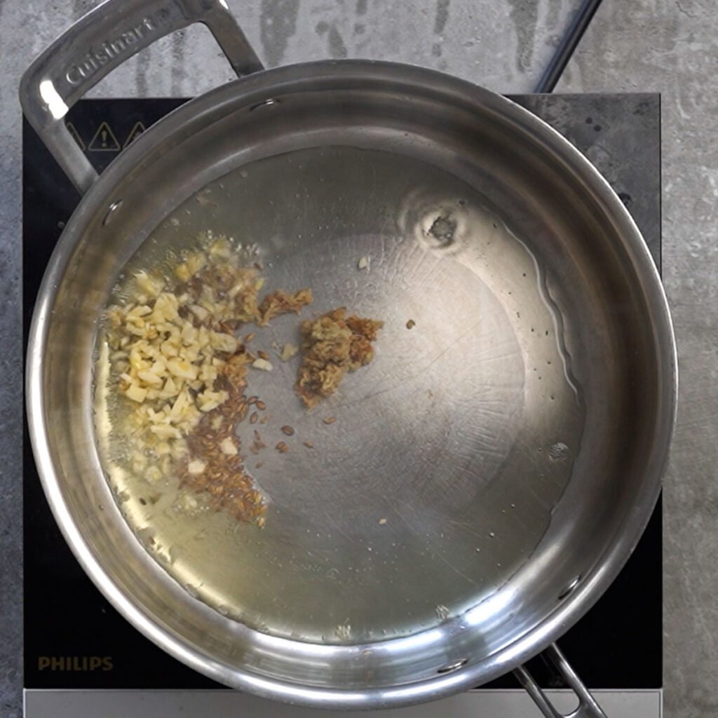 ginger garlic and cumin in a hot pan with oil