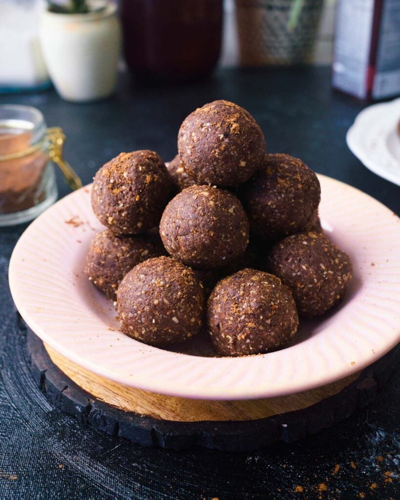 Chocolate Date Protein Energy Bliss Ball  in a pink shallow bowl 