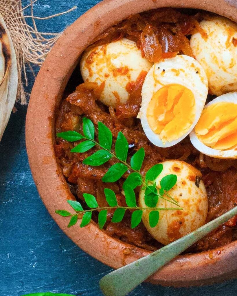 Egg Roast Masala in a earthen pot with parottas