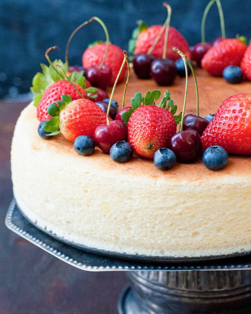 Japanese fluffly cheesecake decorated with strawberries, cherries and blueberries.