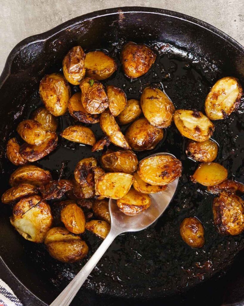 Crispy roast potatoes in a black cast iron pan