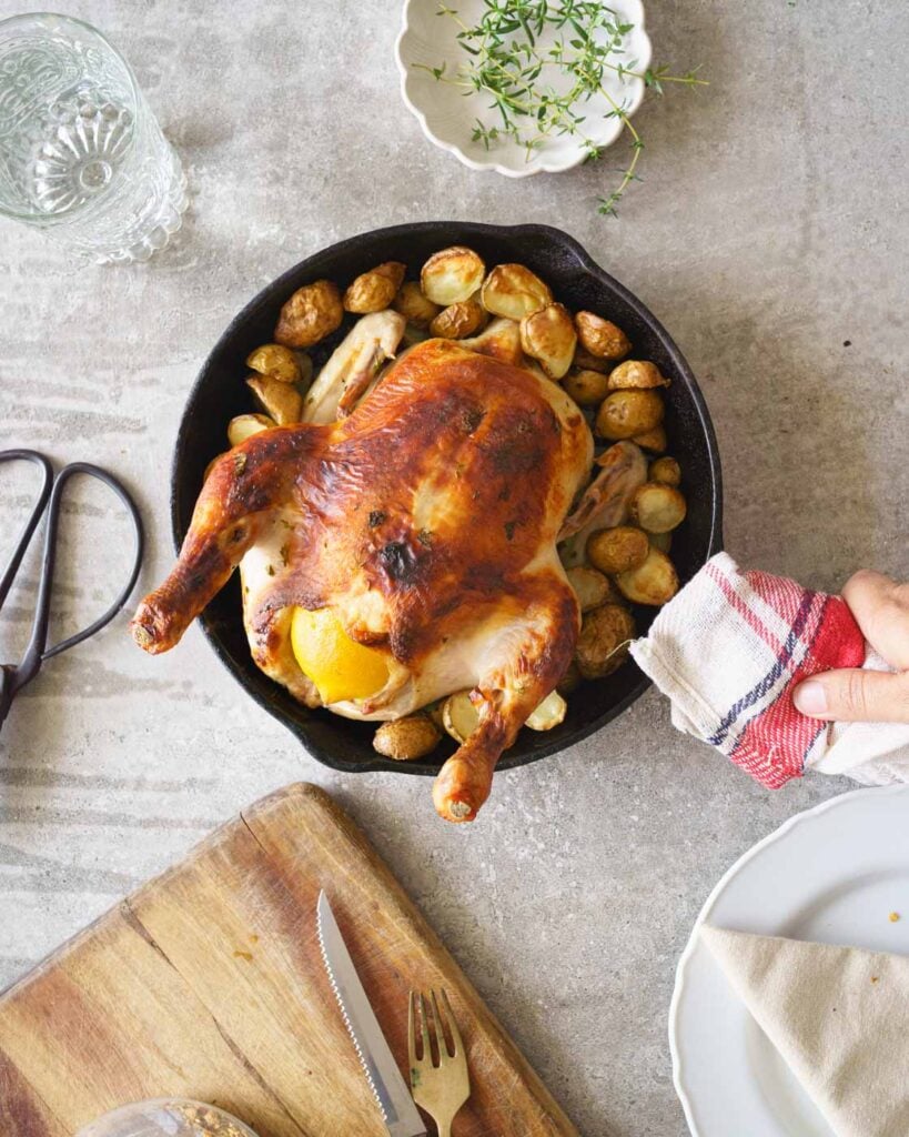 Buttermilk roast chicken with potatoes in a black cast iron pan