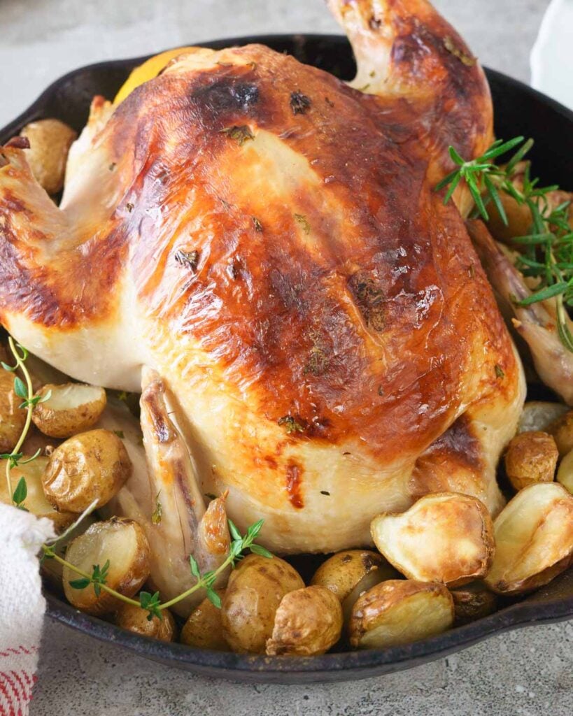 A rotisserie chicken in a pan.