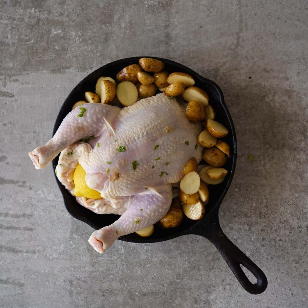 Buttermilk marinated whole Chicken with a lemon and baby potatoes,  ready to be roasted