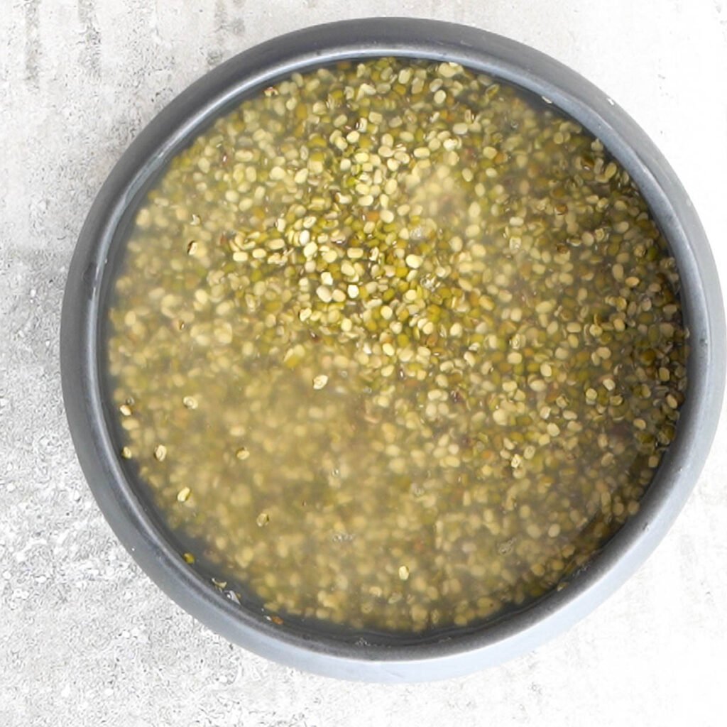 Soaked Moong Dal in a black bowl