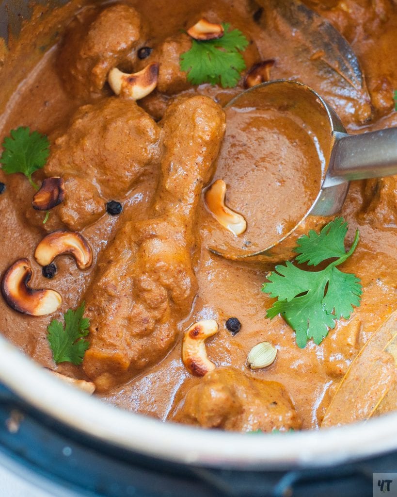 chicken korma in instant pot with cashews, peppercorn and a ladle