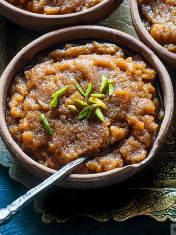 Aate Ka Halwa or Kada Prasad in a bowl with green pistachios on top.