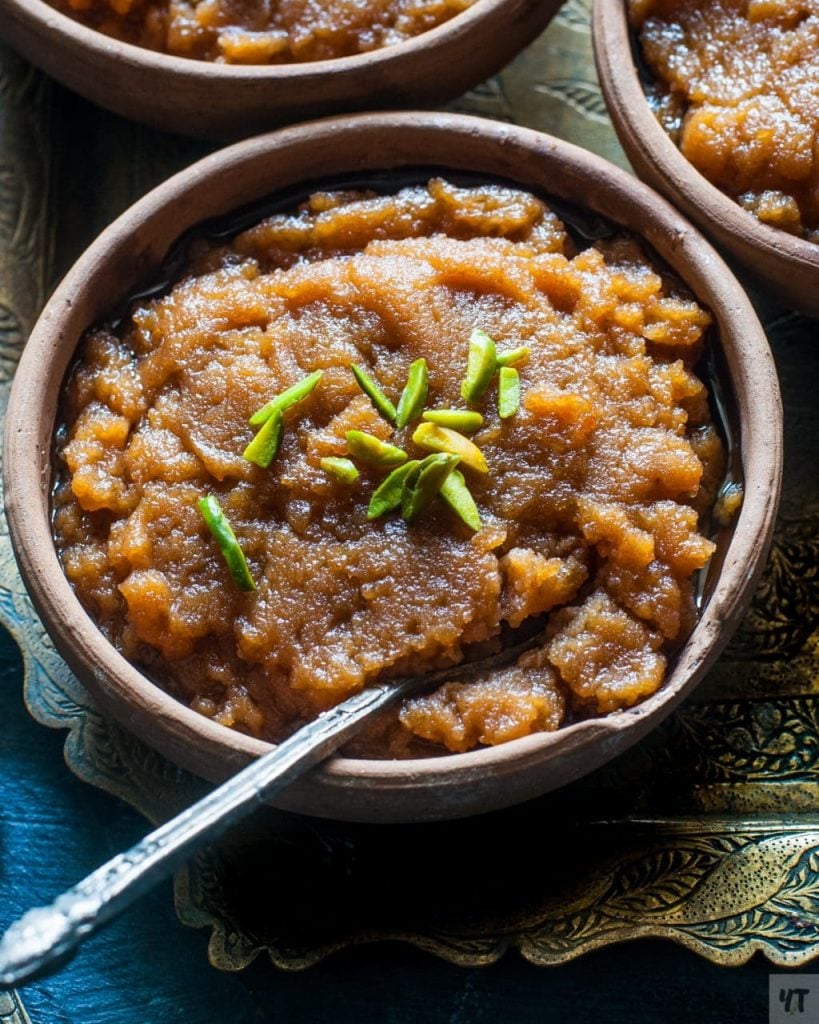 Aate Ka Halwa or Kada Prasad in a bowl with green pistachios on top.