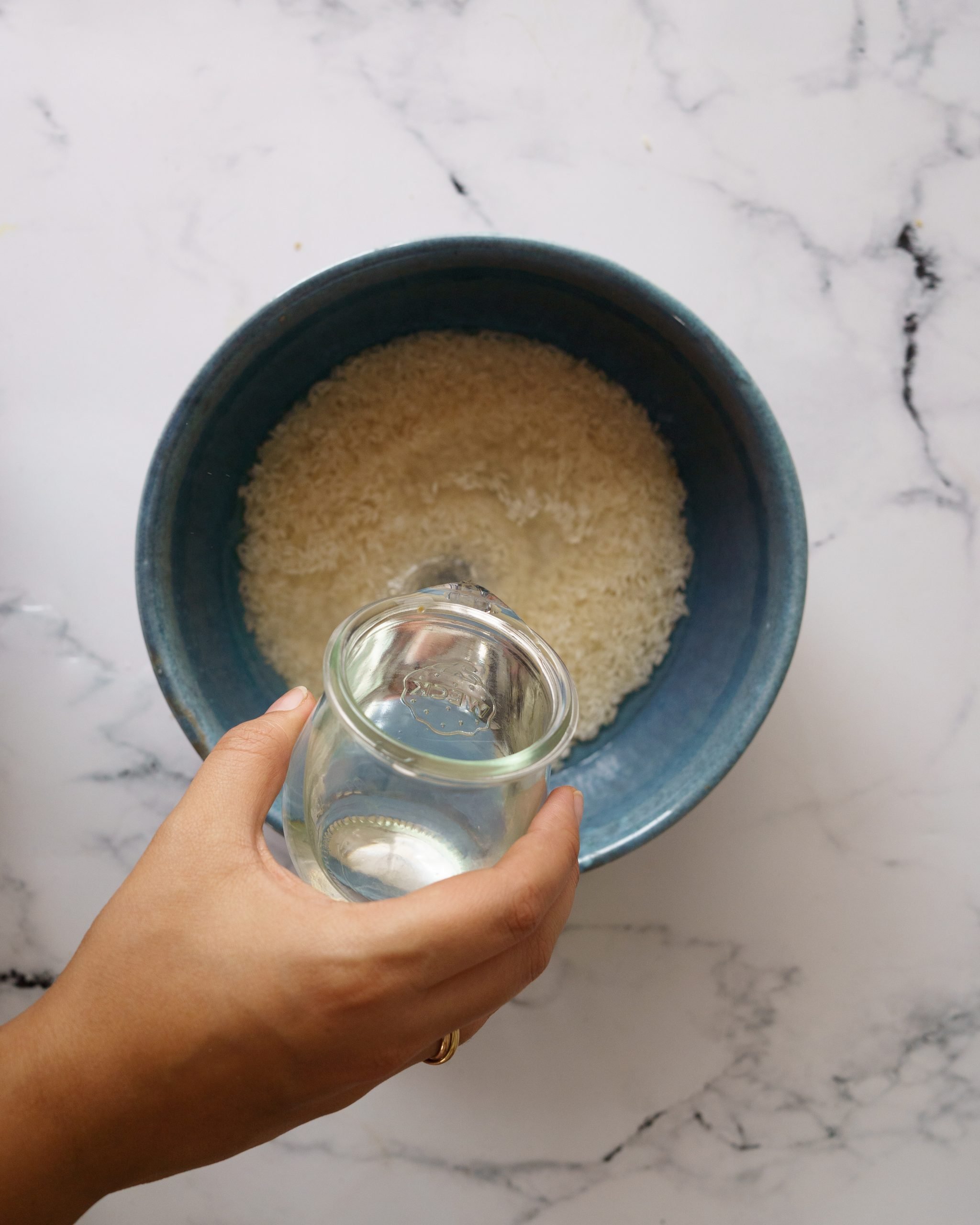 washing the rice in blue bowl