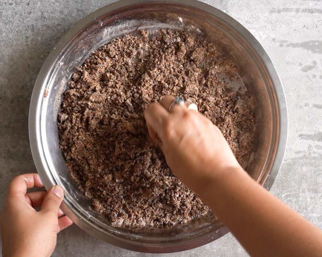 Mixing toasted Ragi, Powdered nuts and ghee