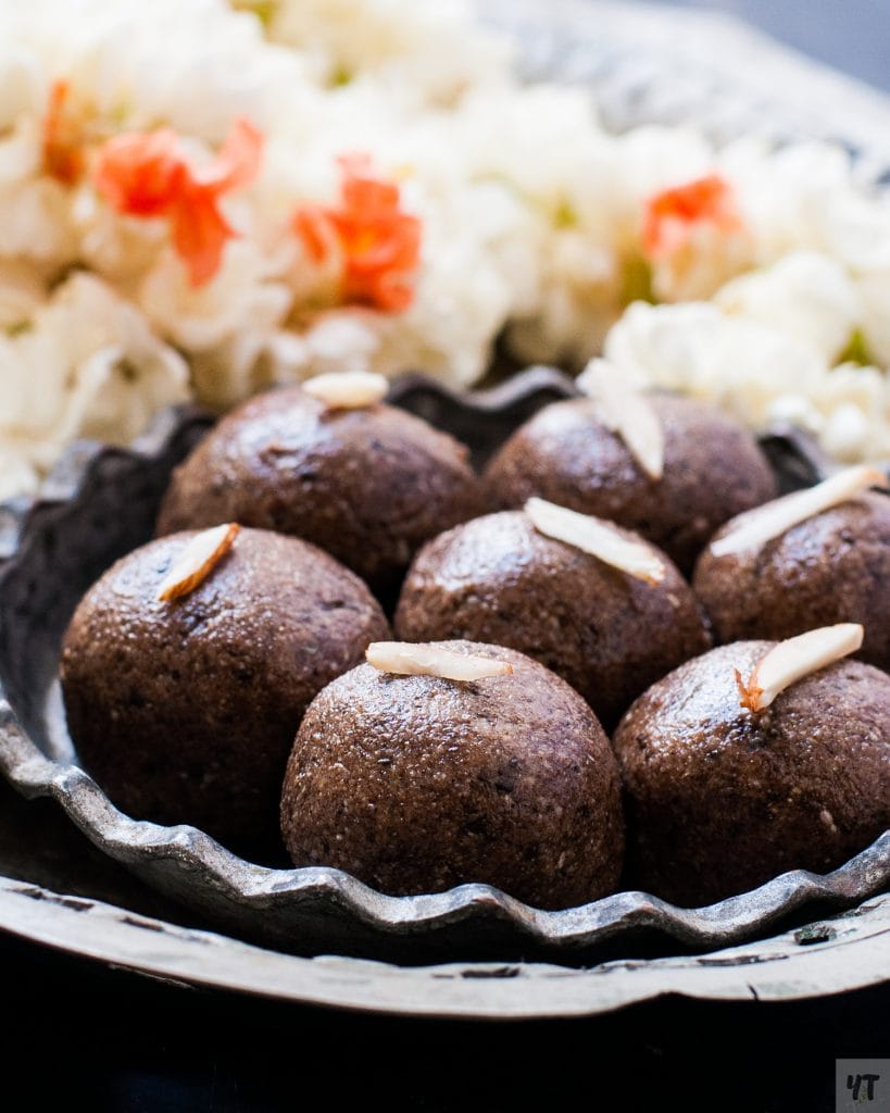 Close up of Ragi Laddu - Finger Millet ladoo. Dark Brown Sweet balls garnished with slivered almonds