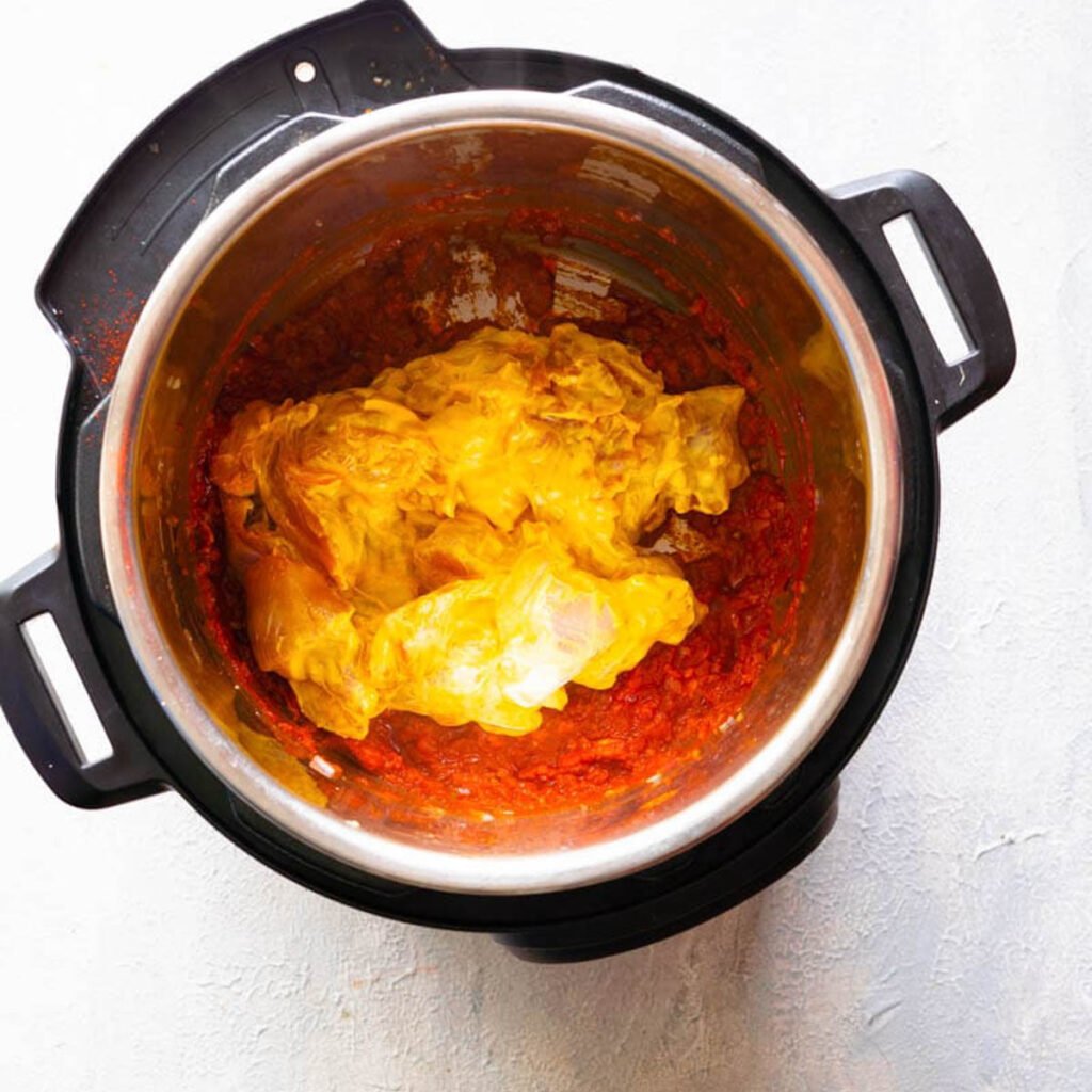 adding chicken to the butter chicken base sauce in the instant pot