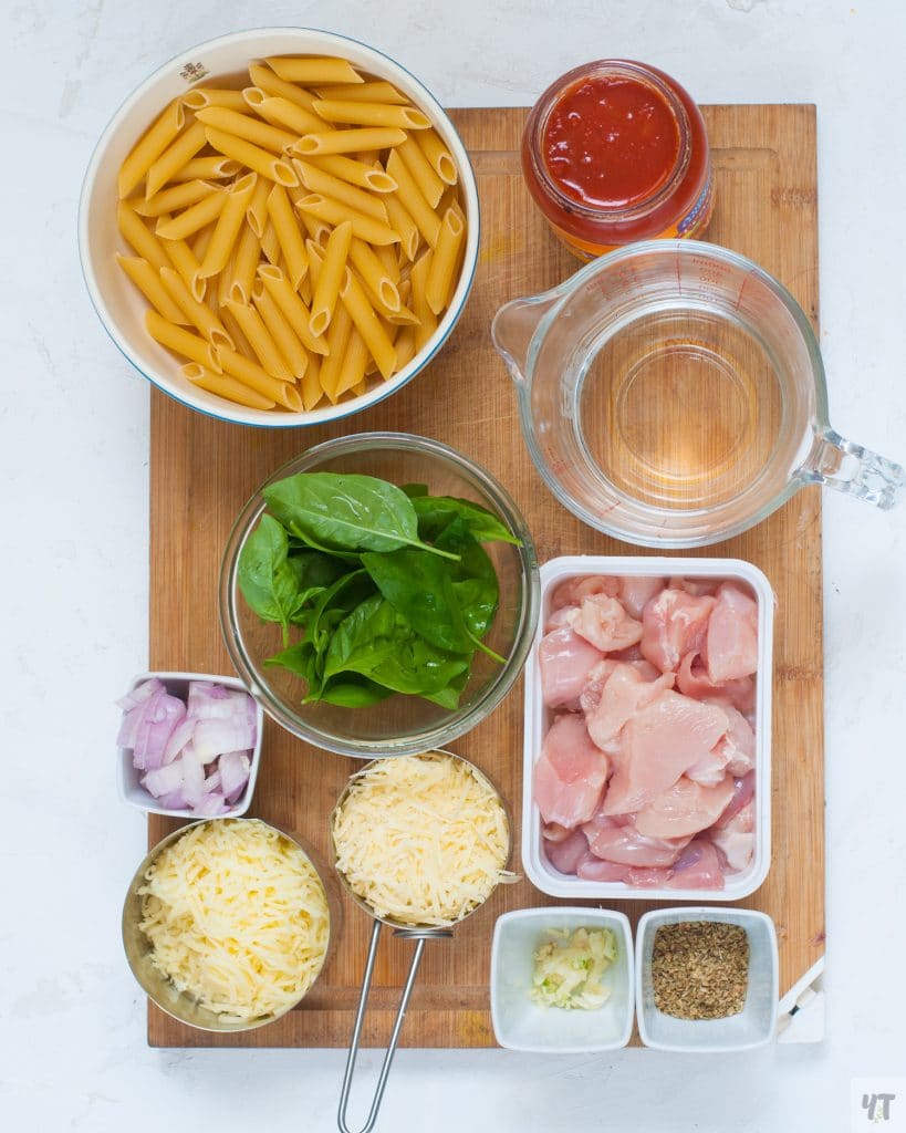 Ingredient shot for chicken parmesan - chicken, cheese,penne pasta, cut onion, garlic,italian seasoning