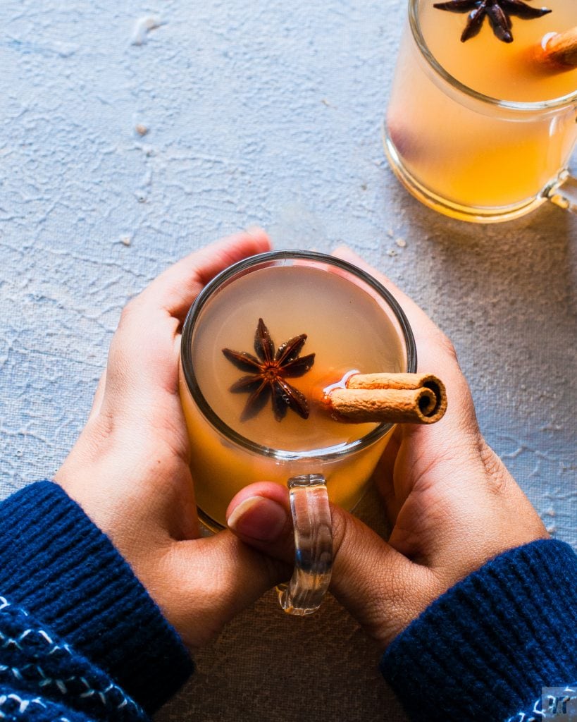 Warm Instant Pot Apple Cider in a glass, with star anise