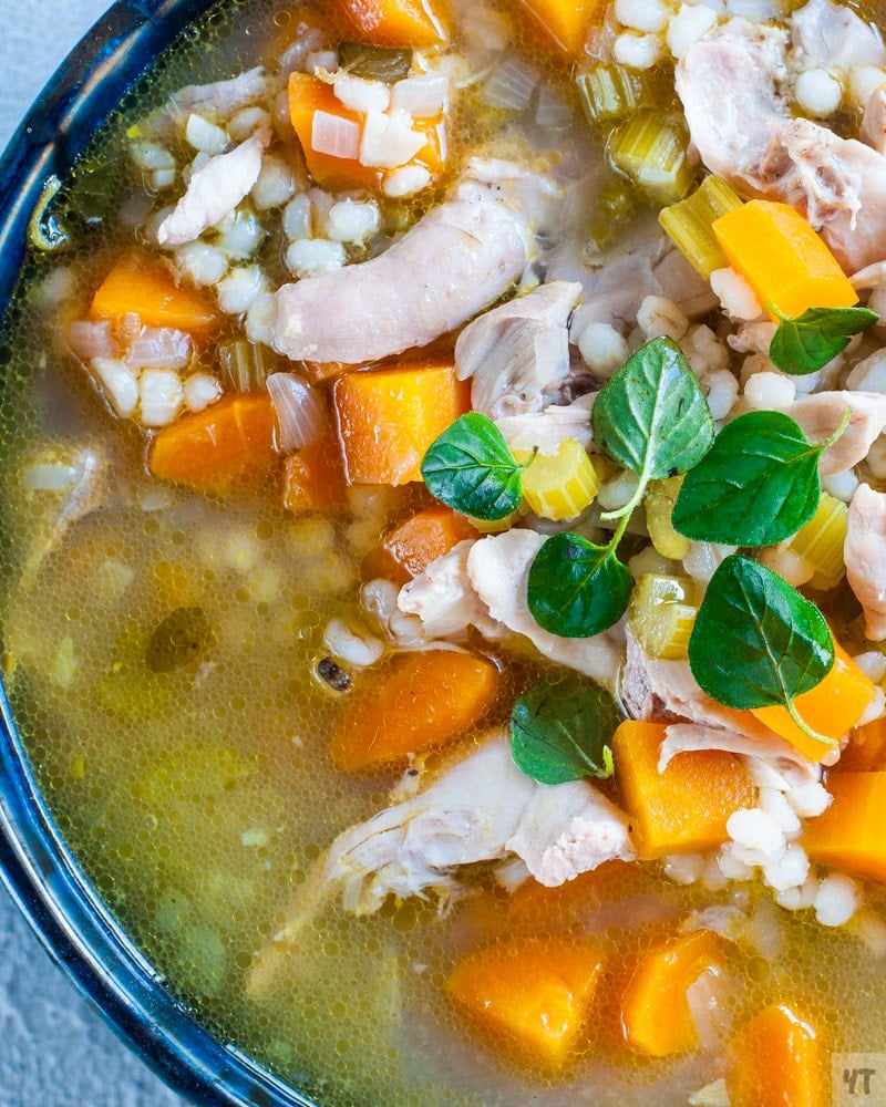 Close up of Instant Pot Chicken Barley Soup in a blue bowl