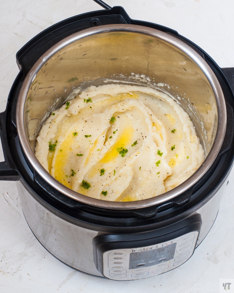 Mashed potatoes in the instant pot with melted butter and fresh parsley