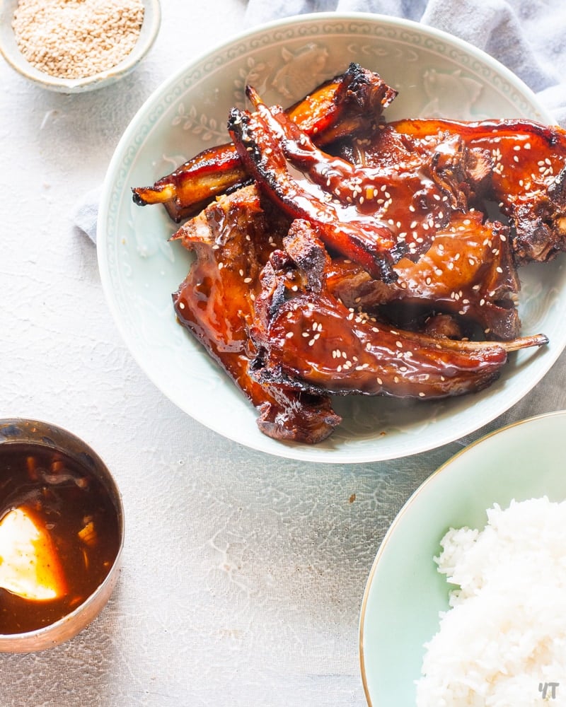 Instant Pot Spare Ribs with Sweet and Spicy Sticky Chinese Sauce in a light green bowl with sesame seeds