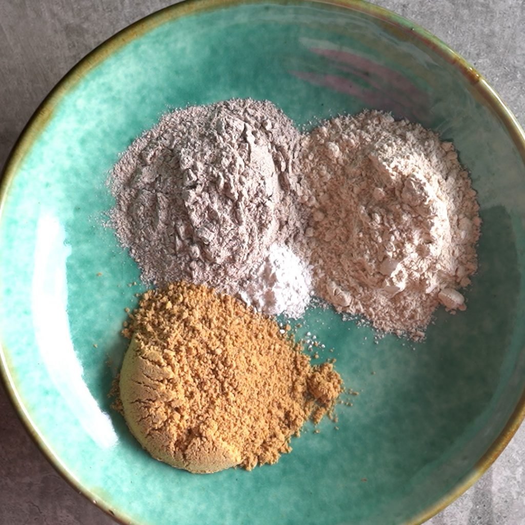 mixing dry ingredients in a shallow green bowl to make Ragi cookies