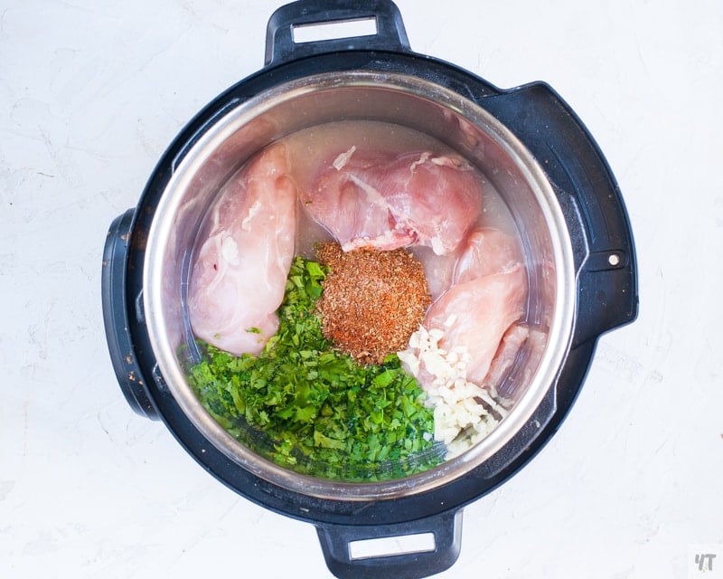 Chicken breast, cilantro, garlic and taco seasoning in the instant pot