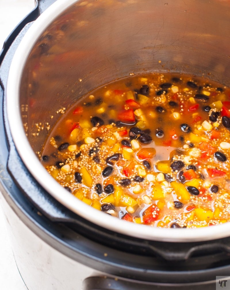 Quinoa, beans, bell peppers and enchilada sauce with water in the instant pot to make maexican quinoa