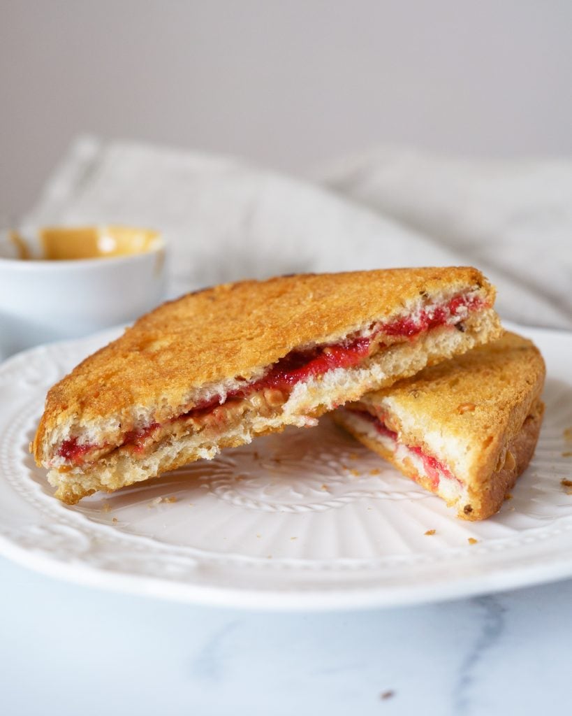 Air Fried Peanut Butter and Jelly cut into triangles on a white plate
