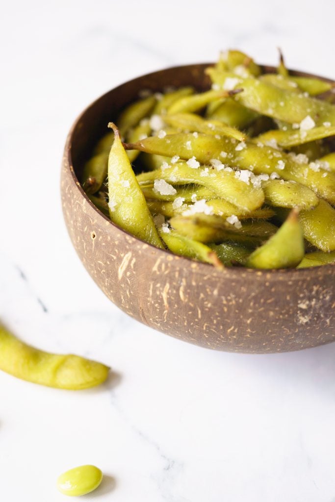 Edamame in a brown bowl with sea salt