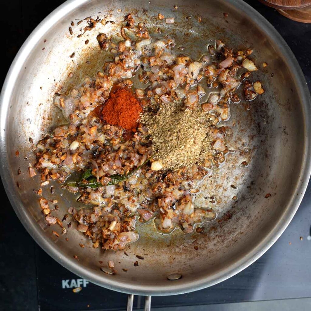 Chili powder and Coriander powder along with Browned onions in a steel pan