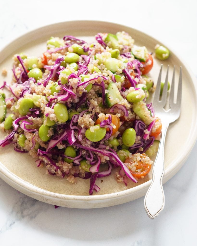 Edamame Quinoa salad in a white plate with a fork