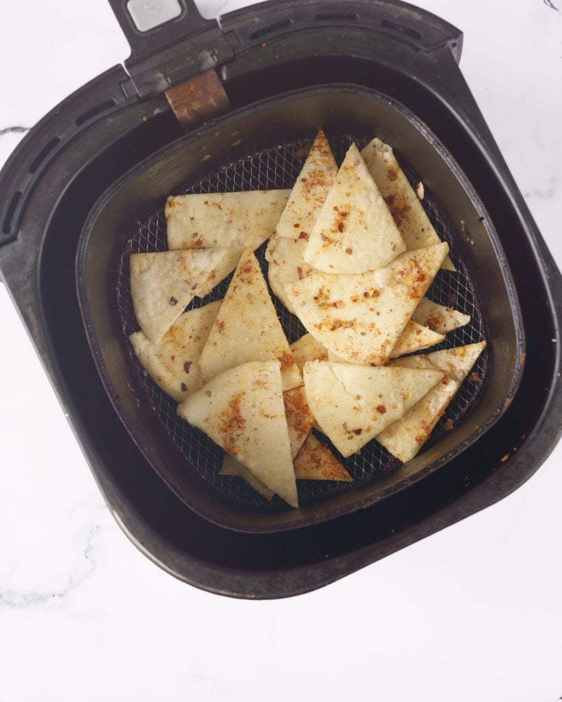 uncooked pita chips in the air fryer basket