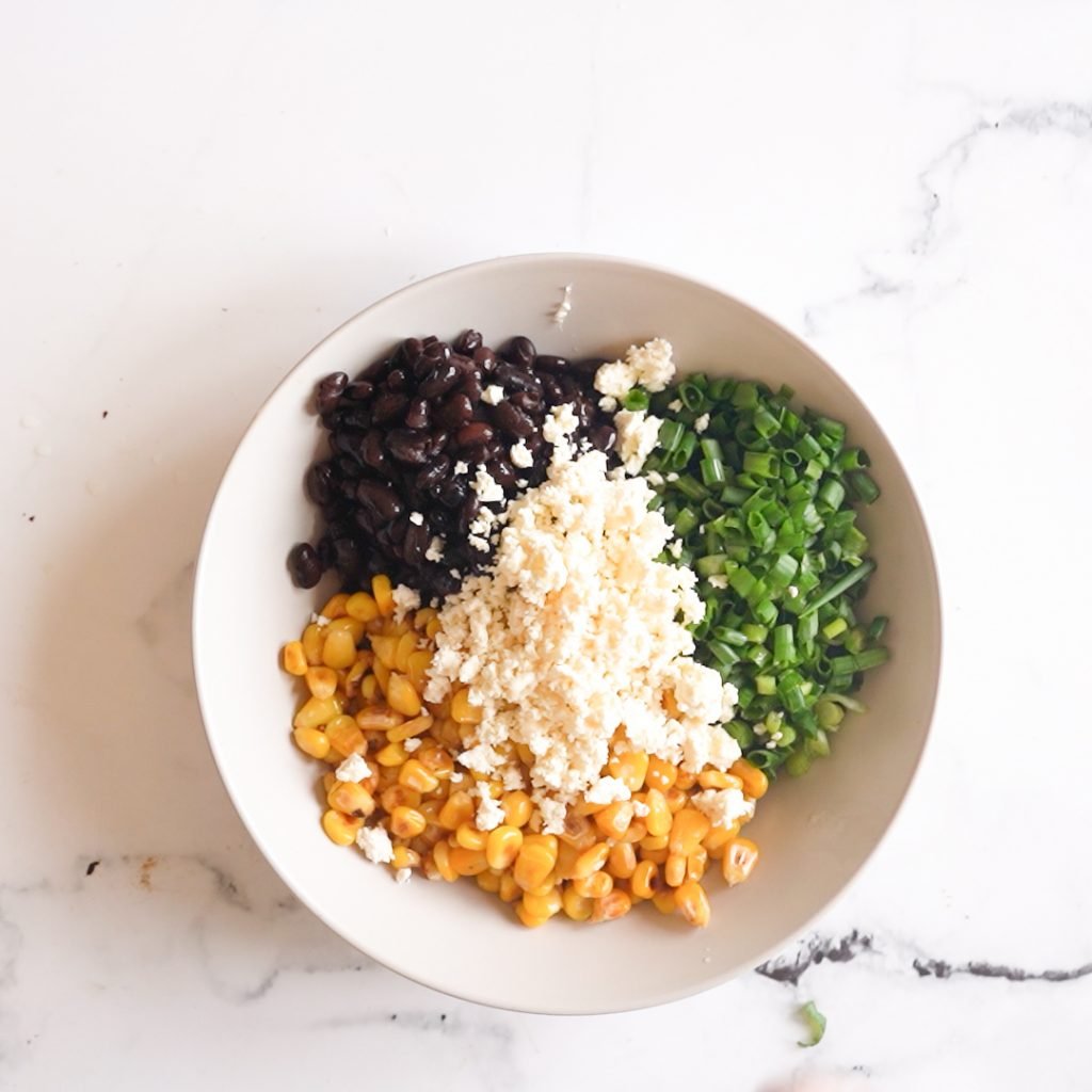 Vlack bean corn and feta in a grey bowl