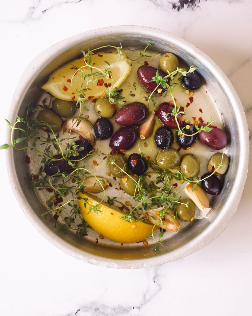 Olives, herbs, lemon, garlic and olive oil in a baking dish