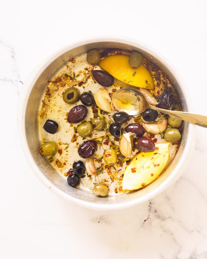 Olives, herbs, lemon, garlic and olive oil in a baking dish