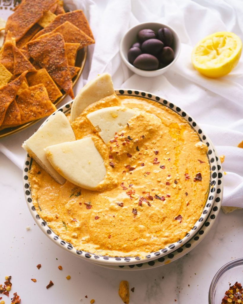 lots of pita breads dipped in the roasted red pepper dip