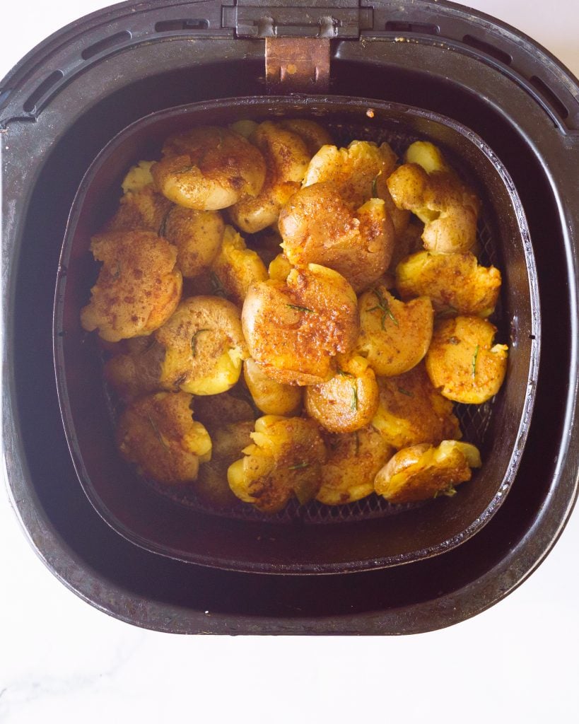 smashed potatoes inside the air fryer basket