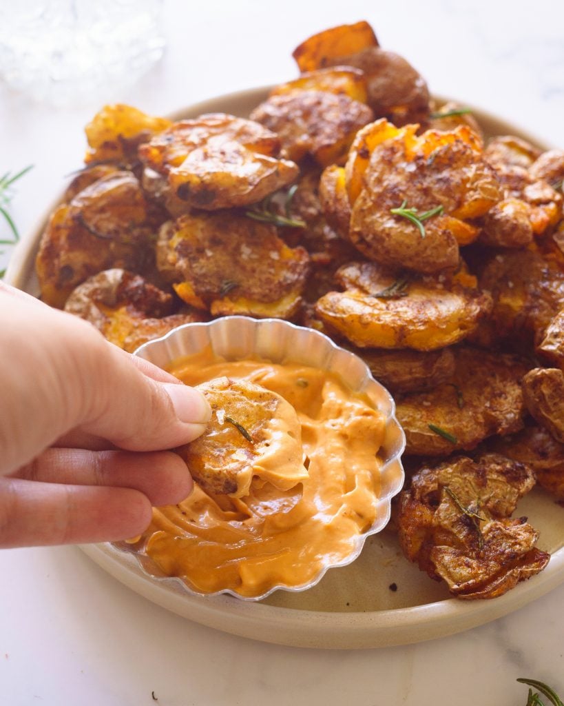 Dipping the Crispy Smashed Potatoes in the spicy dip