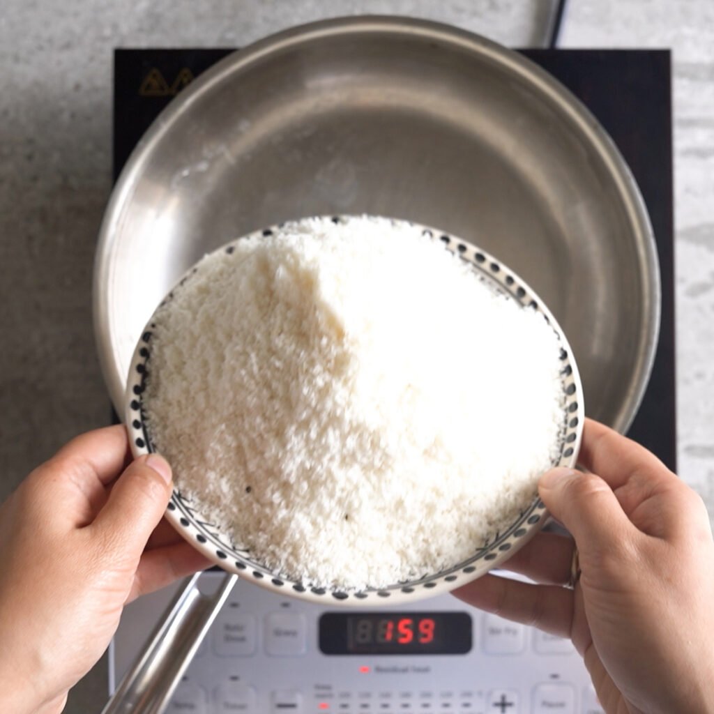 Toasting the coconut for coconut laddu with condensed milk