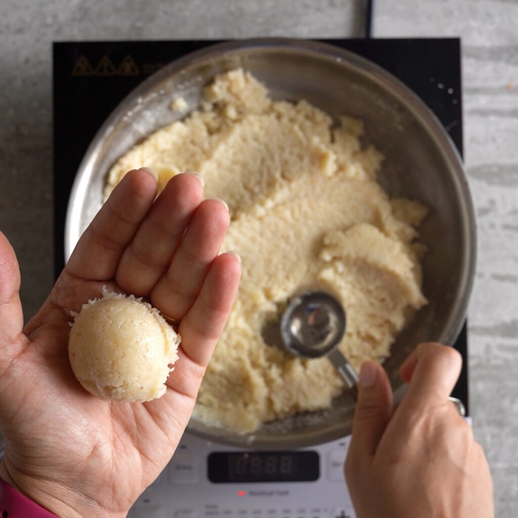 Use a tablespoon to take out 1 tablespoon of laddu mixture and roll