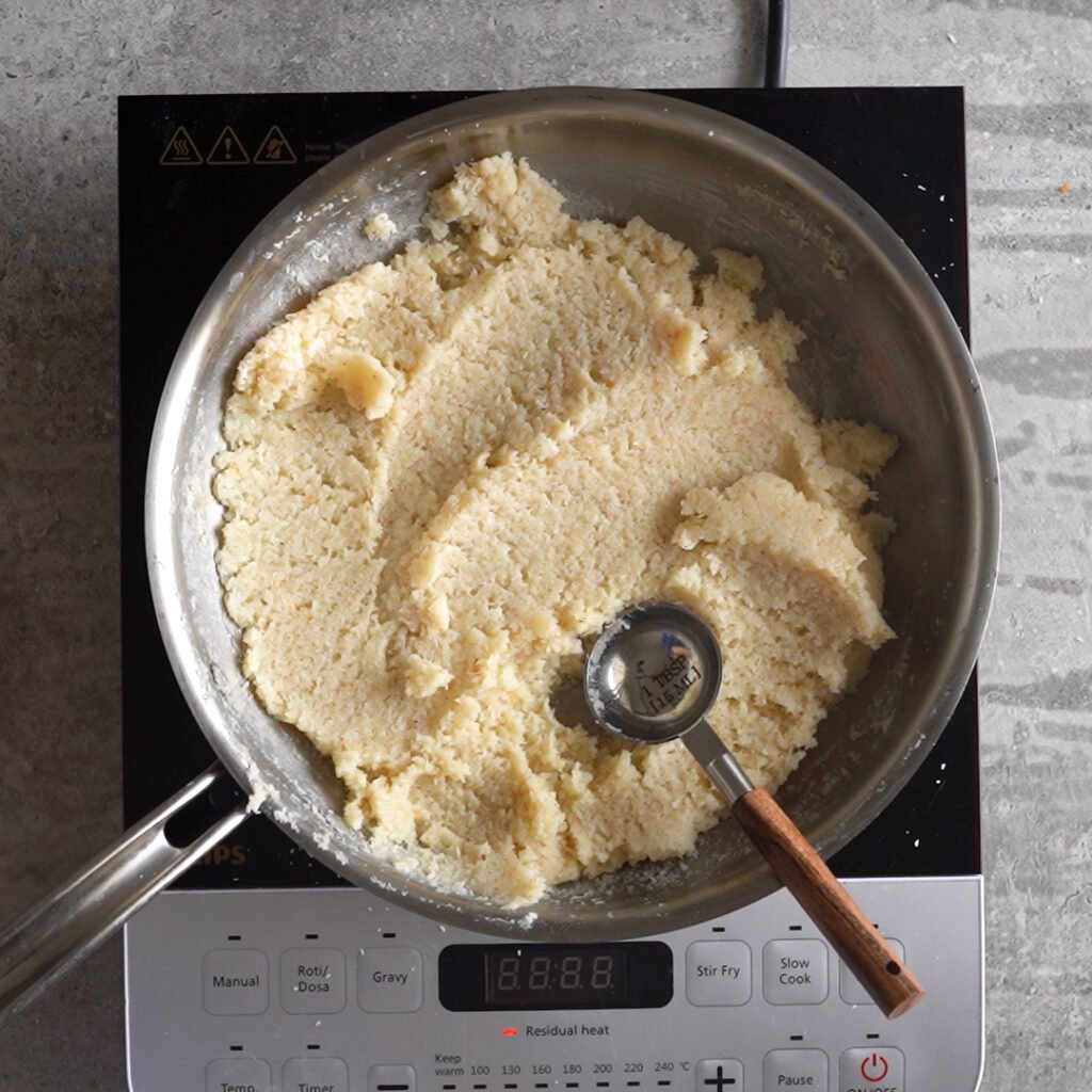 Use a tablespoon to take out 1 tablespoon of laddu mixture and roll