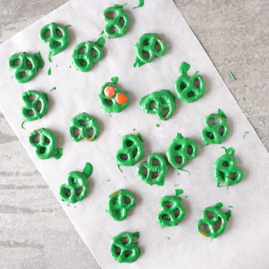 Drying Halloween Alien Pretzel Treats on parchment paper