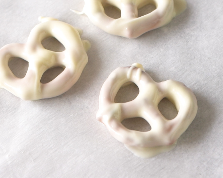 White chocolate covered pretzel on a parchment paper