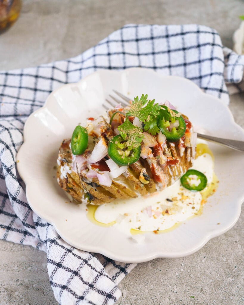 Loaded Hasselback potatoes with cream, onions, jalapeno and sriracha