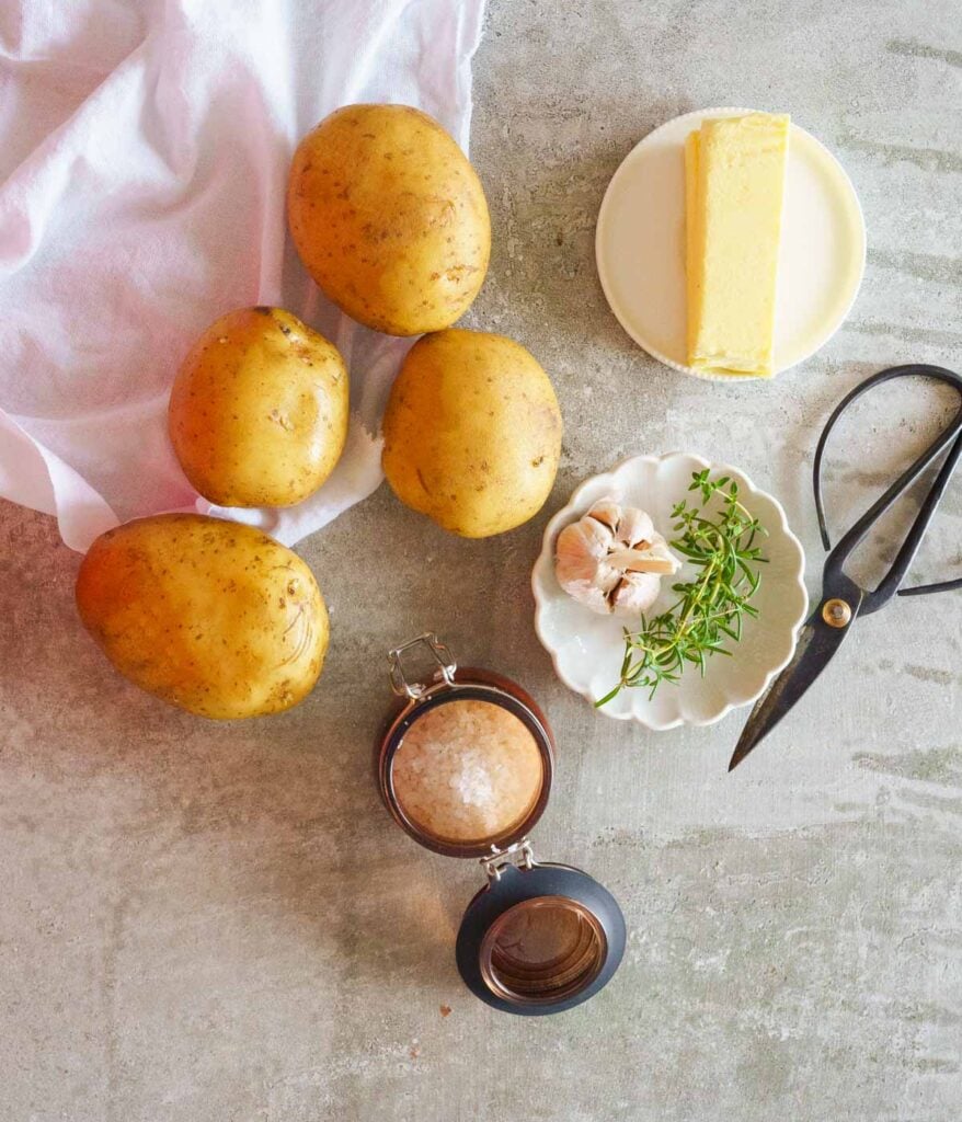 Ingredients needed to make Hasselback potatoes - medium sized potatoes, salt, garlic, herbs & Butter