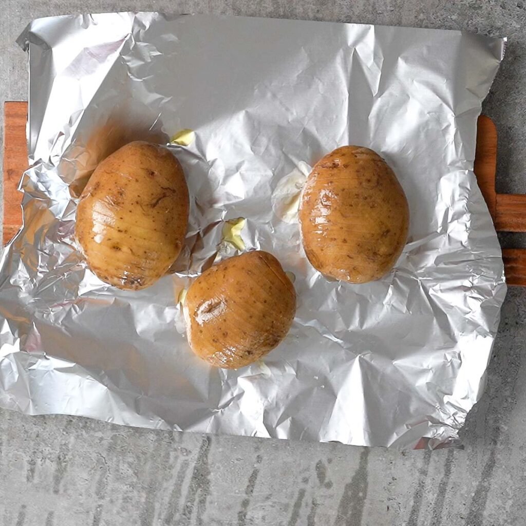 Cut and olive oil rubbed potatoes on top of a foil