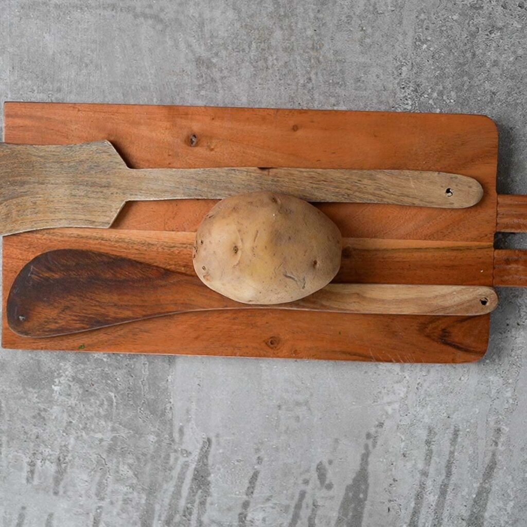 Cutting a medium sized potato that's kept between two wooden spatulas to cook hasselback potatoes