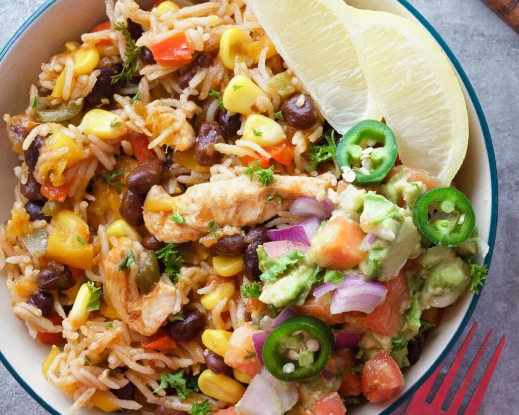 Instant Pot mexican rice burrito bowl in a cream bowl with a chuny guacamole