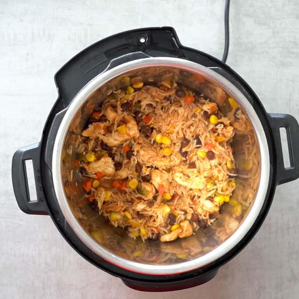 Instant Pot mexican rice burrito bowl - Cooked rice with salsa, beans, chicken , corn and bell peppers