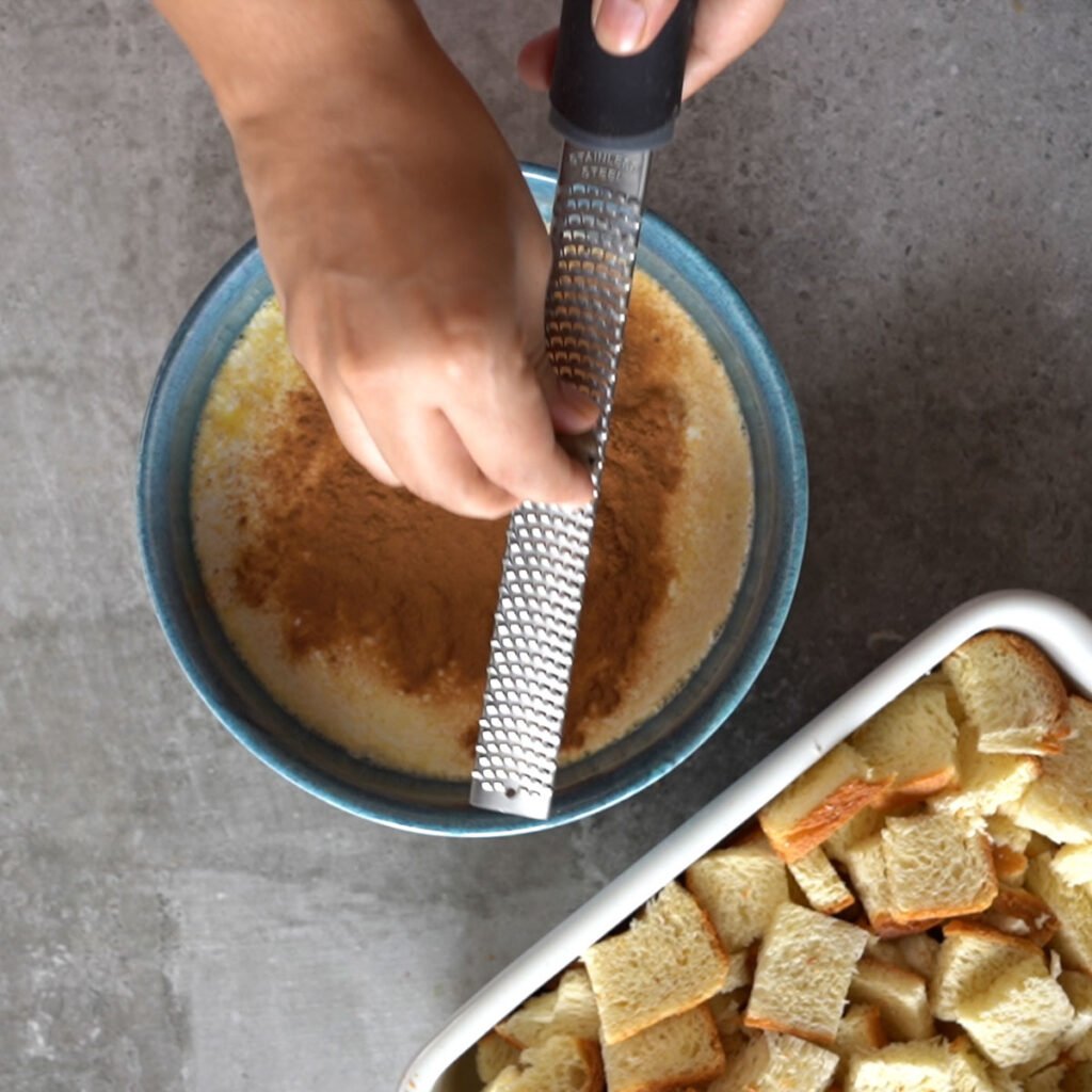 Grating nutmeg over the custard to make french toast